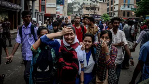 NurPhoto/Getty Images A woman cries after clashes with police during a student protest in Dhaka on August 5, 2018