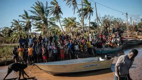 Getty Images People stranded by Cyclone Idai wait for rescue by the Indian Navy on March 22