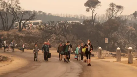 Getty Images People evacuate from Mallacoota, Australia during bushfires (3 Jan 2020)