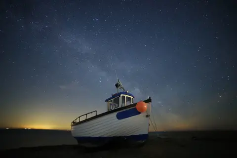 Susan Pilcher A fishing boat seen on the water beneath a night sky