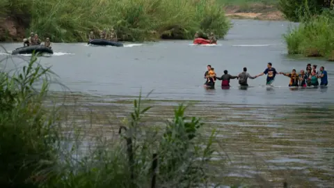 Getty Images Migrants in the Rio Grande at Eagle Pass in 2022