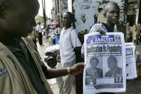 AFP A Liberian street newsagent presents the front pages of a newspaper, 07 November 2005 in Monrovia, on the eve of the second round of the Liberian presidential election