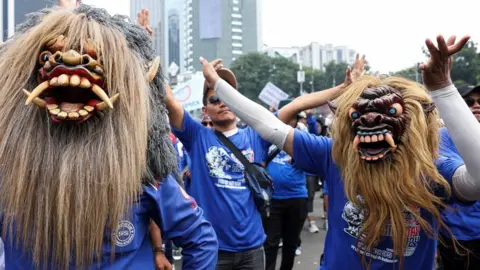 Reuters Labourers wear traditional Indonesian Buto masks as they attend a May Day rally in Jakarta.