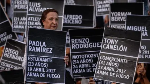 AFP Venezuelan opposition activists take part in a peaceful demonstration carrying black placards with the name of one of the 125 people killed in past protests on each one, in Caracas on August 30, 2017.