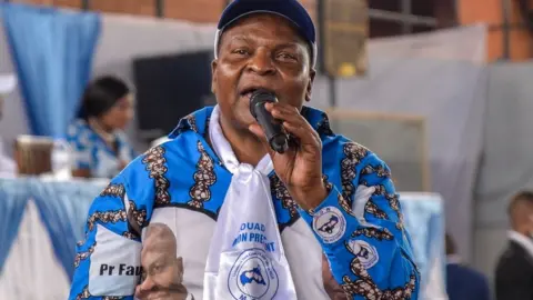 AFP Central African Republic President Faustin Archange Touadera adresses supporters during a rally of the United Hearts Movement (MCU) political party at the Omnisport Stadium in Bangui on March 18, 2022