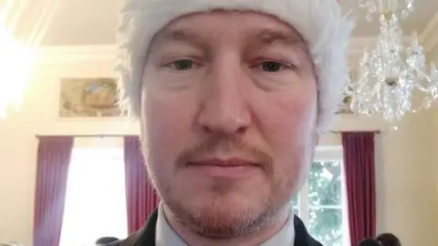 Shaun Slator/Twitter A recent image of Shaun Slator wearing a Christmas hat