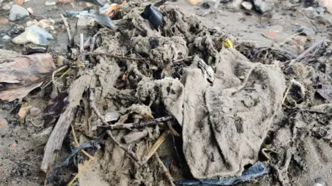 Muddy wet wipes collecting by the Thames