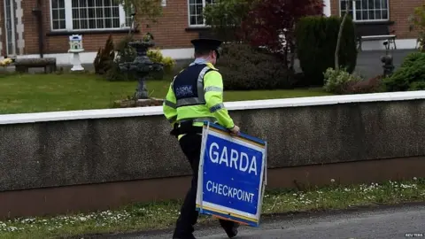 Reuters An Irish police officer removes a Garda checkpoint sign at the Armagh and County Louth border between Northern Ireland and Ireland, during a visit by European Union Chief Negotiator for Brexit Michel Barnier