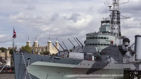 Getty Images The HMS Belfast pictured on the River Thames in London on a clear day, with a union flag at its front
