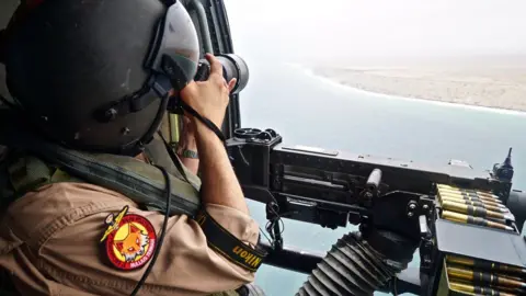 BBC Man with a machine gun overlooking the sea