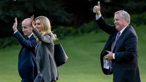 Getty Images Senior advisor for policy Stephen Miller, White House Press Secretary Kayleigh McEnany and White House Chief of Staff Mark Meadows waves to guests
