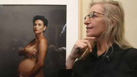 Getty Images Photographer Annie Leibovitz speaks to the media while standing in front of a portrait of pregnant actress Demi Moore during a walk-through of the exhibition "Annie Leibovitz - A Photographer's Life 1990-2005" at the C/O Gallery on 20 February 2009 in Berlin