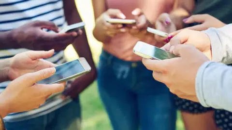 Getty Images Teenagers on mobile phones