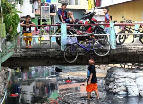 Getty Images Children in kampungs, overly populated neighbourhoods.