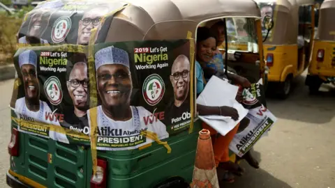 AFP Rickshaws emblazoned with campaign posters bearing images of the opposition Peoples Democratic Party election candidate Atiku Abubakar and his running mate Peter Obi stand on a road in Abuja, Nigeria - Monday 19 February 2019