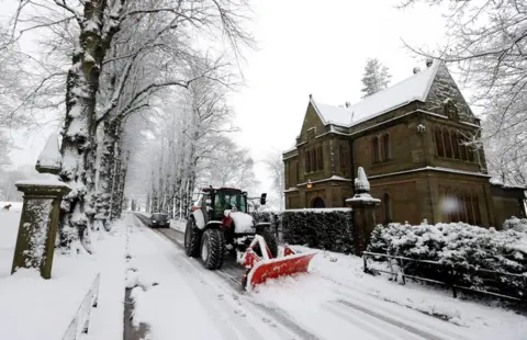 Reuters A snowplough clears a street in Keele, Staffordshire, Britain, 29 December 2020