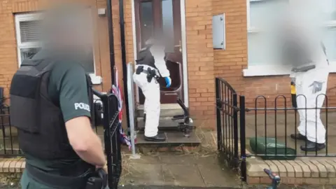 Police at one of the homes searched during the operation