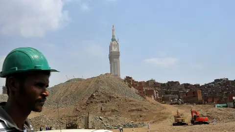 AFP A construction worker is seen at a large housing and hotel construction project, as slums are earmarked for demolition to make way for new buildings around the Mecca's clock tower and Grand Mosque, in the holy city of Mecca, on October 9, 2013.