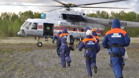 Russian emergencies ministry Russia's emergencies ministry rescuers run to a helicopter. File photo