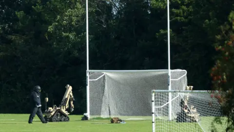 Pacemaker bomb disposal robots next to goalposts