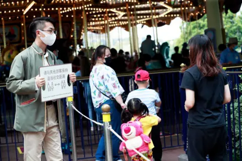 China News Service/Getty Images A worker holding a sign