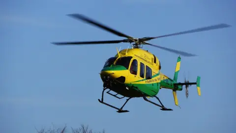 Wiltshire Air Ambulance Image of a Wiltshire Air Ambulance helicopter in the sky. It is yellow and green.