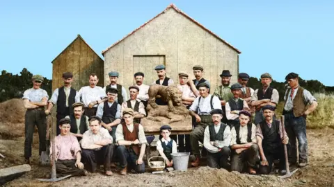 Fairless Family A group of men and boys standing with uncovered stone lion