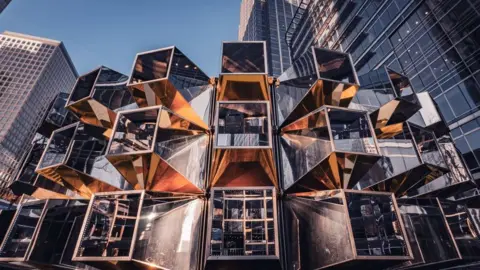 Alan Hayes A series of reflective cubes stacked on top of one another