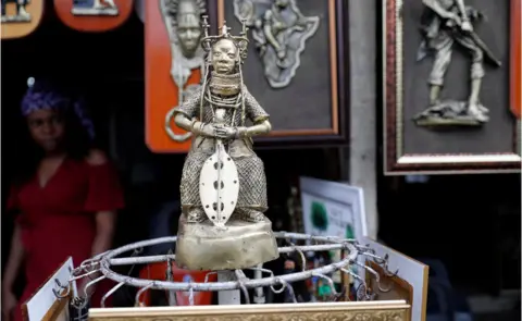 Reuters A bronze work is displayed for sale in front of a shop in Benin City, Edo state, Nigeria (photo released on 20 June)