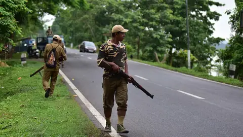 Getty Images Forest officials stand guard in Nagaon district of Assam