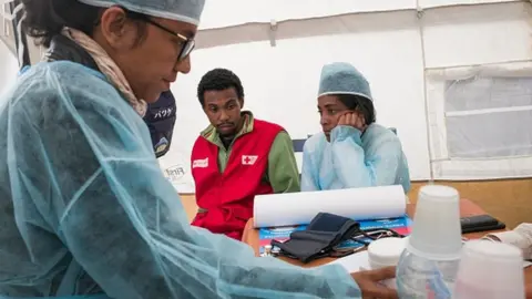 AFP Doctors and nurses from the Ministry of Health and officers of the Malagasy Red Cross staff a healthcare checkpoint at the 'taxi-brousse' station of Ampasapito district in Antananarivo (05 October 2017)