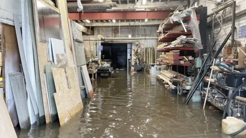 PA Media Flood water inside Kirk and Bill's