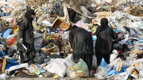 Reuters Iraqi women search for recyclable items at a rubbish dump in Baghdad, Iraq (6 May 2020)