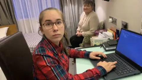 BBC Kateryna tries to do homework in hotel room