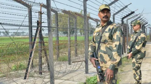 Getty Images Indian Border Security Force personnel walk along a fence at the India Pakistan border on the outskirts of Amritsar on February 27, 2019.