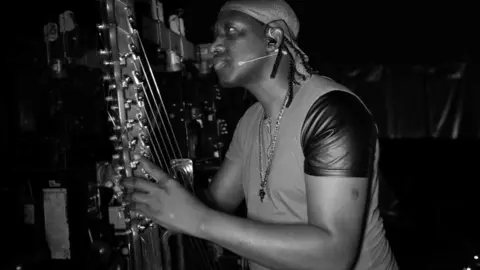 Michael Palmer N'Faly Kouyate looking at his undamaged kora