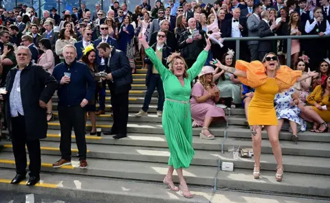 Paul Ellis / AFP Racegoers celebrate at Aintree