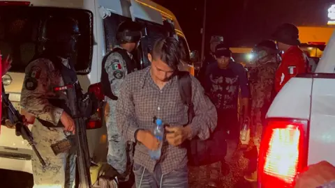 Getty Images A group of migrants board a bus.