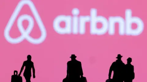 Reuters Figurines in front of the Airbnb logo