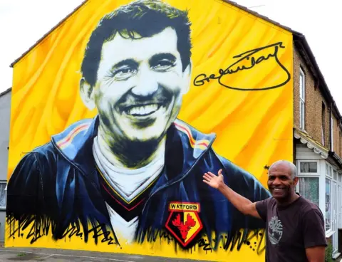 Stephen Danzig Luther Blissett by a mural to Graham Taylor