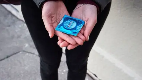 Getty Images woman holding condom