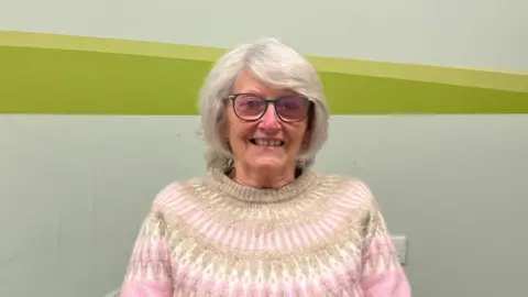 Ollie Conopo/BBC Woman with white hair and glasses