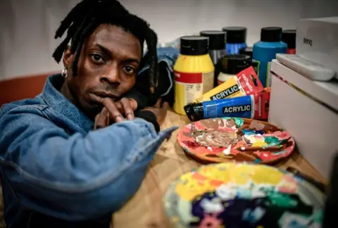 AFP Cameroonian artist Francis Essoua Kalu aka 'Enfant Precoce' poses at his workshop on February 6, 2019 in Paris.