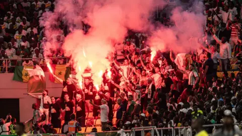 John Wessels/AFP Large crowd holding sparklers, 12 September