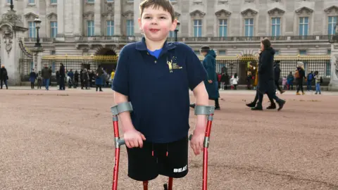 Getty Images Tony Hudgell poses outside Buckingham Palace to celebrate Jack Hopkins running 100 days to raise funds for the Tony Hudgell Foundation on 5 February 2022 in London