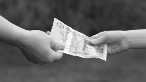 Getty Images Hands exchanging money