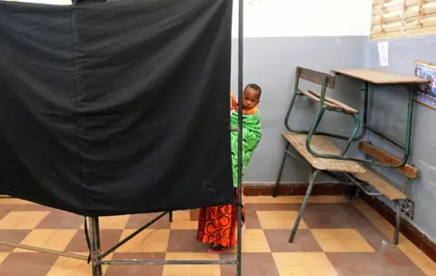 Reuters A woman carries a child as she casts her vote during the presidential election, at a polling station in Medina neighbourhood, Dakar, Senegal February 24, 2019
