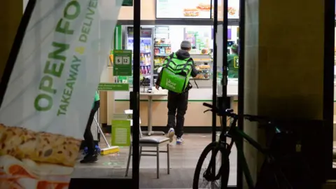 Getty Images An Uber Eats delivery rider picks up an order from Subway