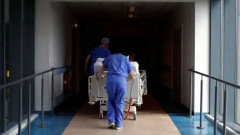 AFP/Getty Images A patient being wheeled through a hospital corridor