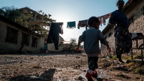 AFP A displaced woman and a child from Western Tigray stand outside of a classroom in the school where they are sheltering in Tigray's capital Mekele on February 24, 2021.